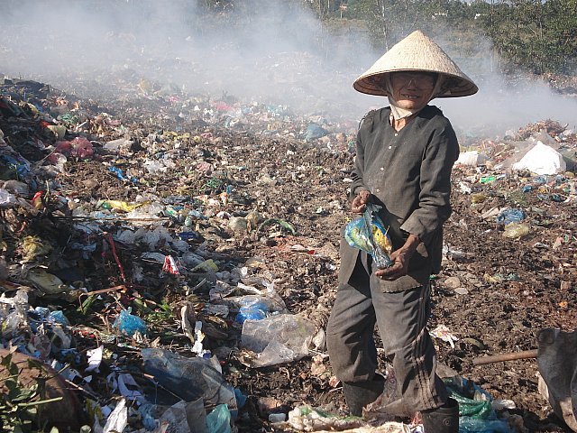 A woman picking junk at a rubbish dump